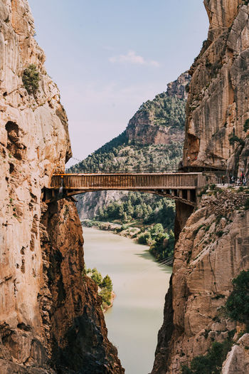 Bridge over river amidst rocky mountains
