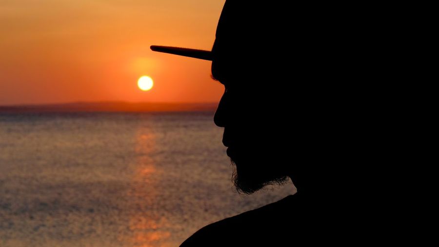 Portrait of silhouette man by sea against sky during sunset