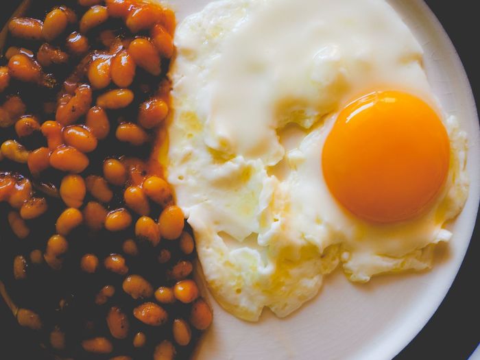 Close-up of baked beans with fried egg