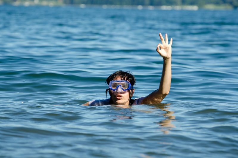 Woman gesturing while swimming in river