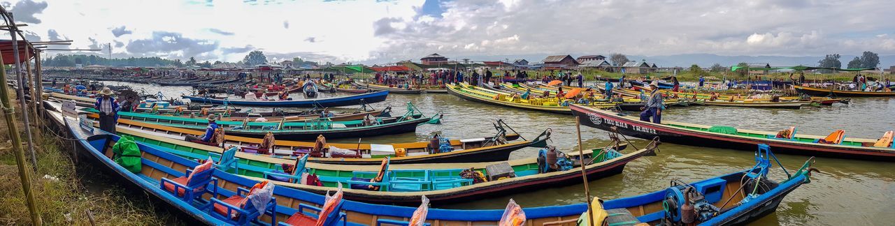 Panoramic view of boats moored at harbor against sky