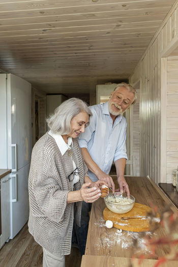 Senior couple preparing dough for bread in kitchen