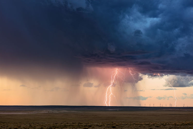 Thunderstorm and lightning strike over a wind farm at sunset near vaughn, new mexico