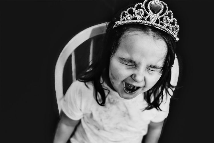 Close-up of girl screaming while sitting on chair