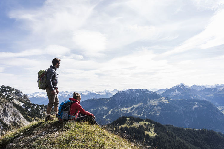 Austria, tyrol, young couple in mountainscape looking at view