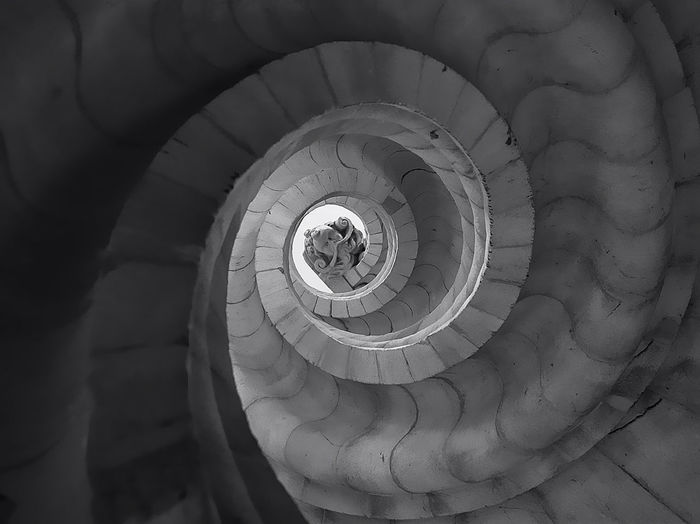 Low angle view of statue seen through spiral staircase