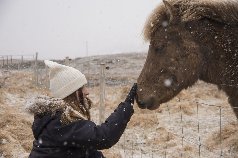 Young woman with horse in winter