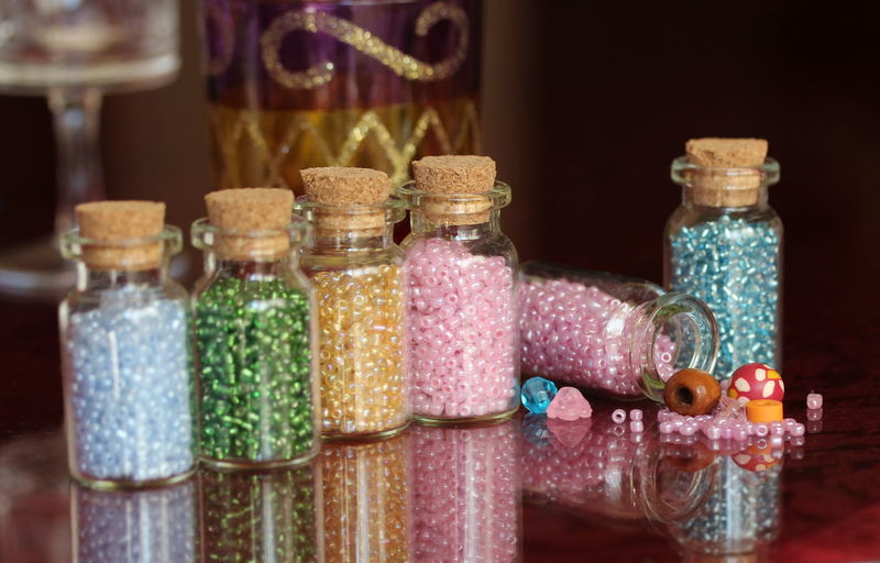 Close-up of multi colored decorations in glass jars on table