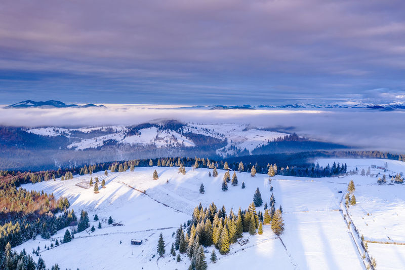 Scenic view of snow covered landscape against sky during sunset