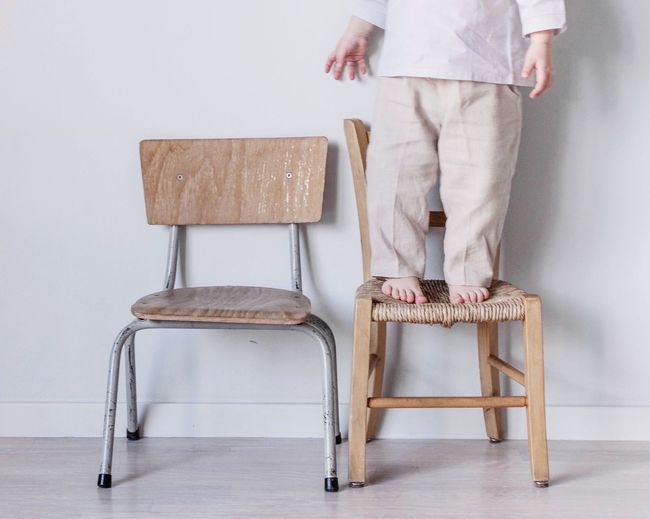 Low section of man standing on chair