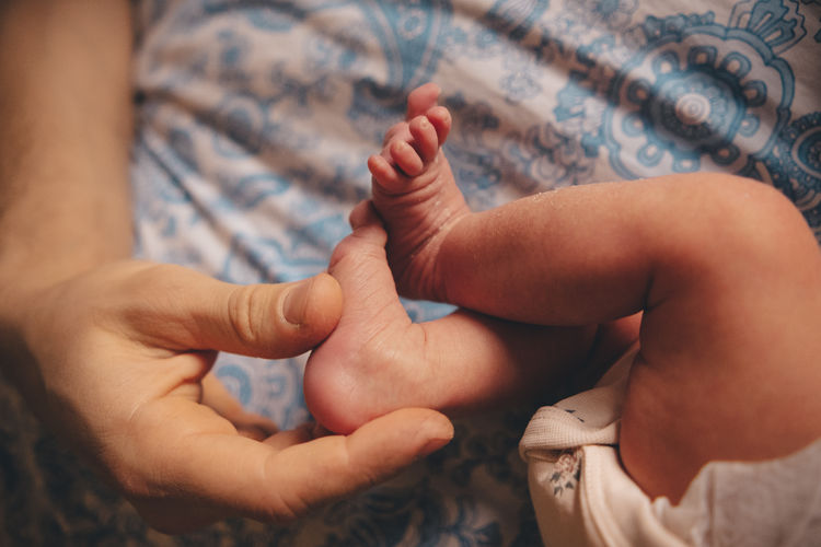 Newborns legs on the bed