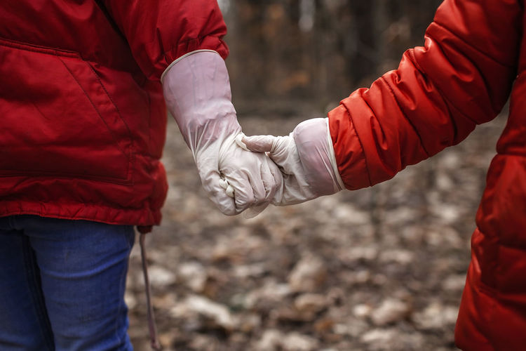 Sister and brother holding hand in hand wearing medical gloves, stay safe concept, social distance