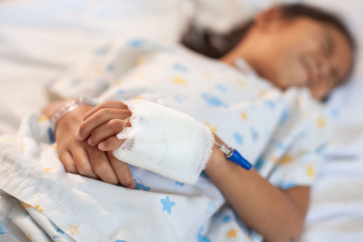 Girl with stomachache lying on bed in hospital