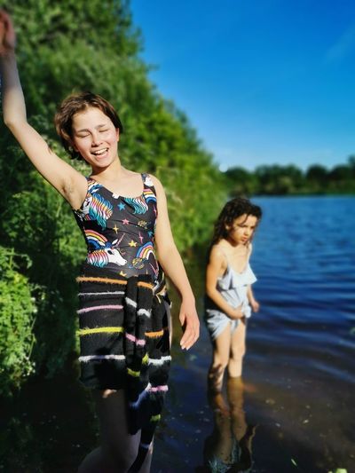 Dual heritage sisters in swimming costumes playing at colwick park lake