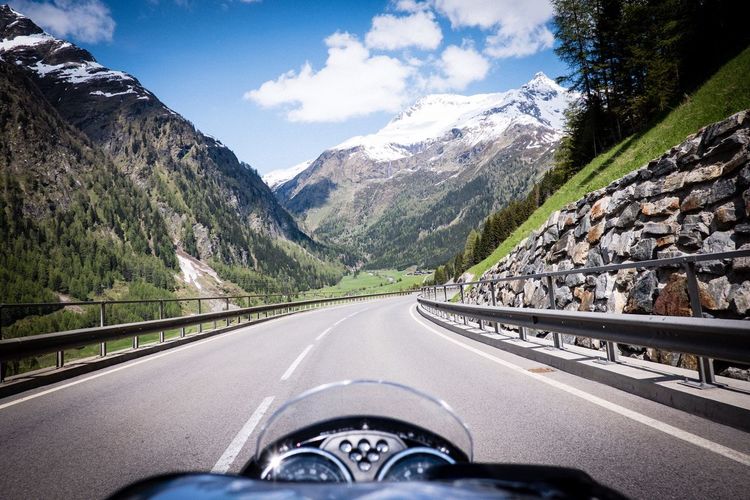Motorcycle on road amidst mountains against sky