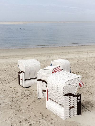 White hooded beach chairs at sandy beach