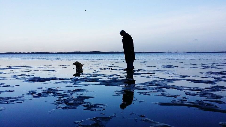 SILHOUETTE OF WOMAN STANDING IN WATER