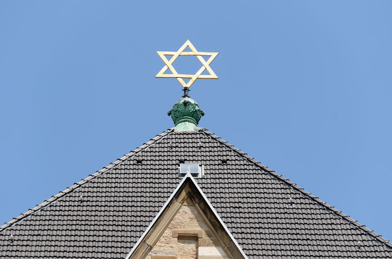 Low angle view of synagoge with star of david against blue sky