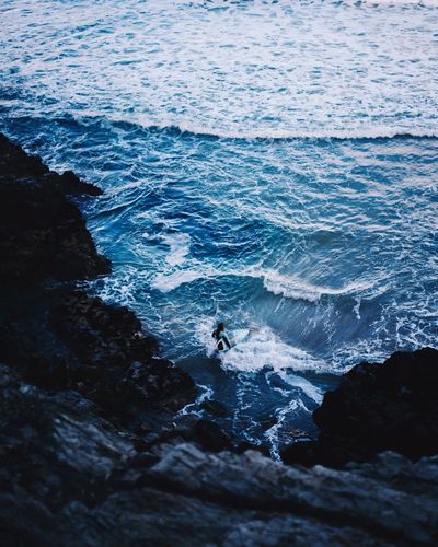 High angle view of woman with surfboard in sea