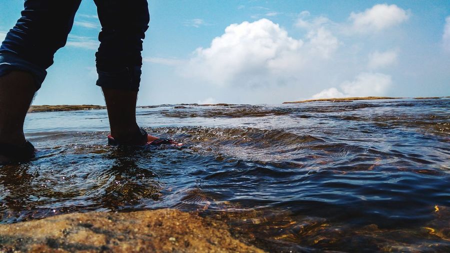Low section of man wading in sea