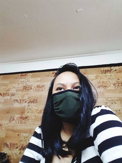 Portrait of young woman against wall at home