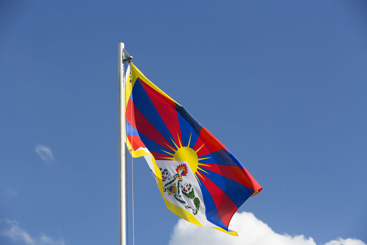 Low angle view of tibetan flag against blue sky