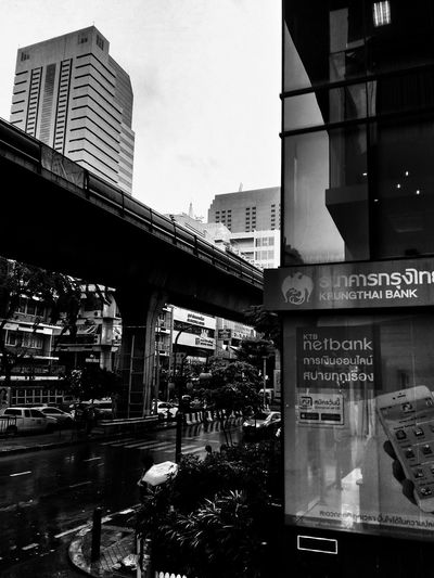 Text on bridge against buildings in city