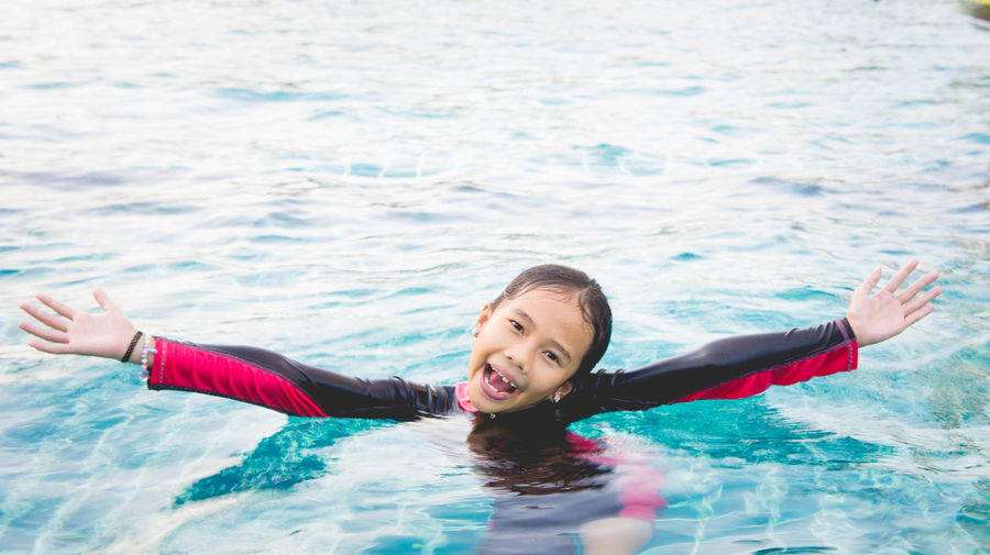 High angle view of smiling girl swimming in sea