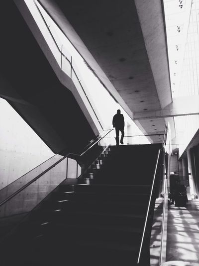 Low angle view of silhouette man walking on staircase