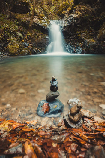 Stacked pebbles against waterfall