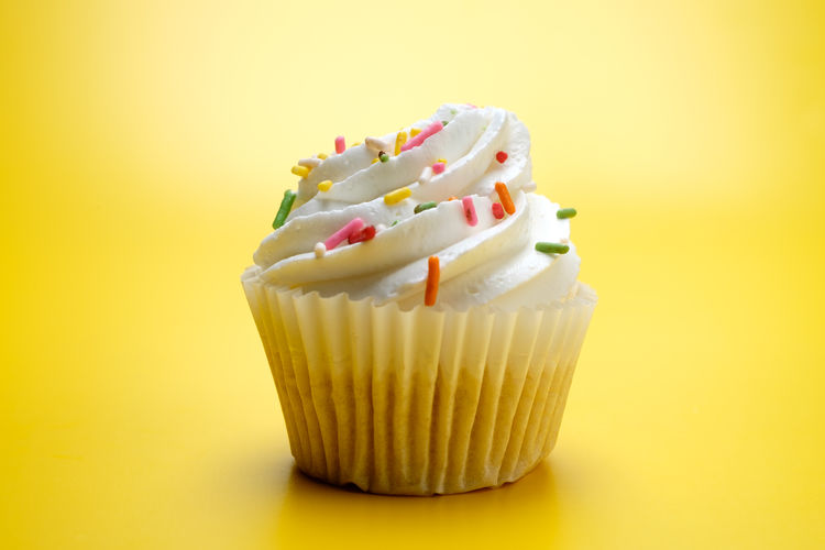 Close-up of cupcakes against yellow background