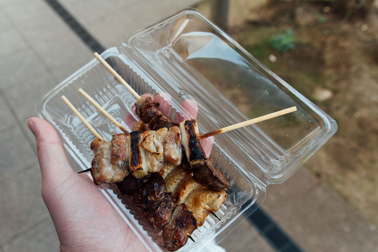 Cropped image of woman holding food in plastic container