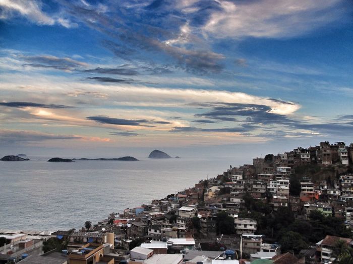 High angle view of slum by sea against sky during sunset