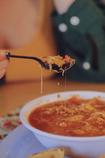 Close-up of woman taking a spoon of mexican food