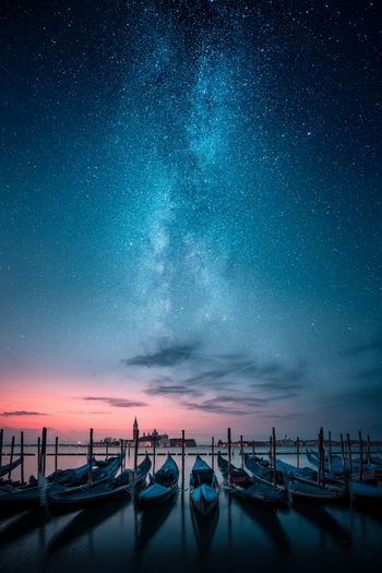 Boats moored on lake at dusk