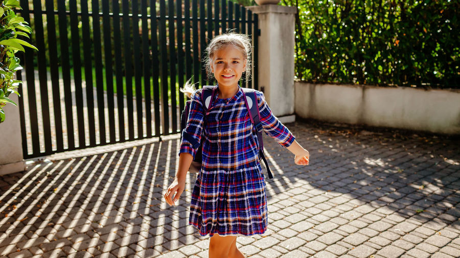 Back to school. girl with backpack runs to school from home at the first day after vacation