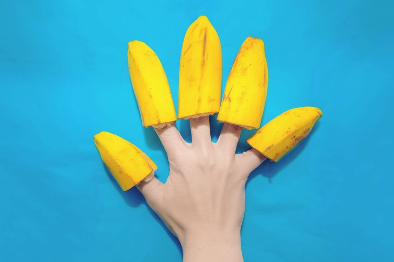 Close-up of woman hand with fruit on fingers 