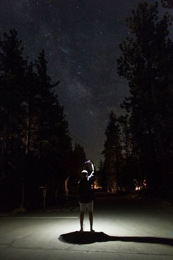 Rear view of man walking on road at night