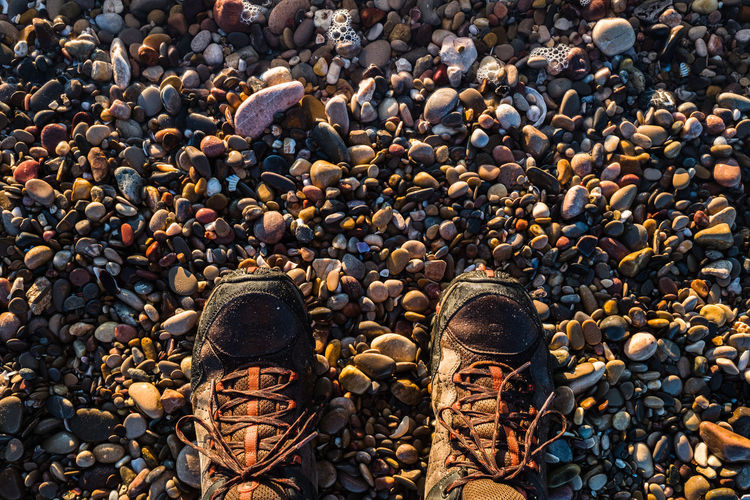 High angle view of shoes over stones on beach