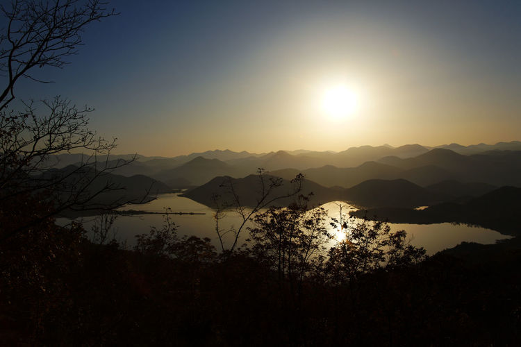 Scenic view of silhouette mountains against sky at sunset