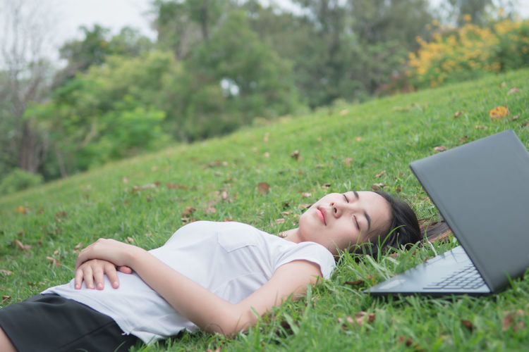 Woman lying down on grassy field