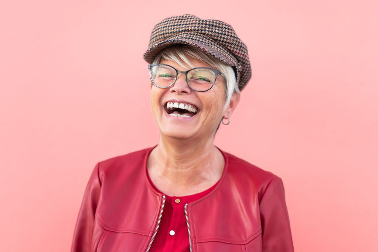 Portrait of happy woman against pink background