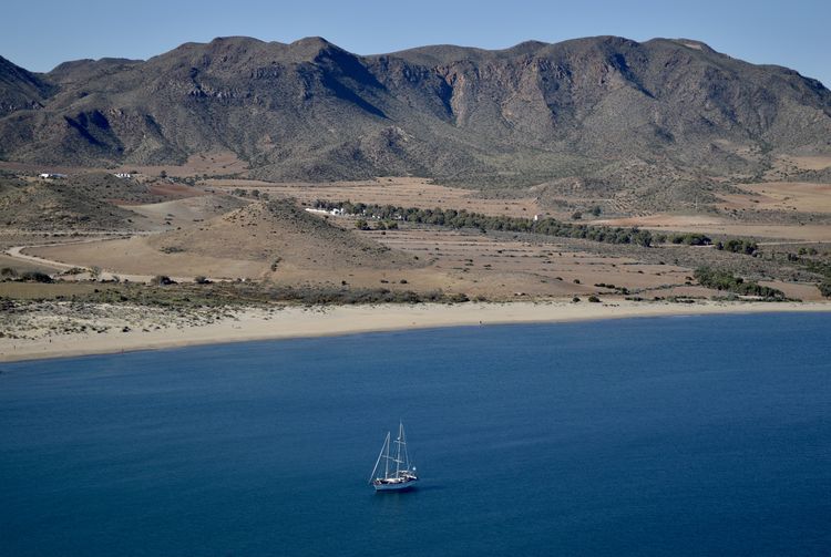 Scenic view of sea and mountains against sky