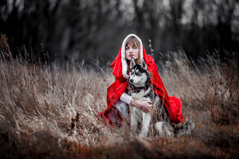 Portrait of woman with dog on field in forest