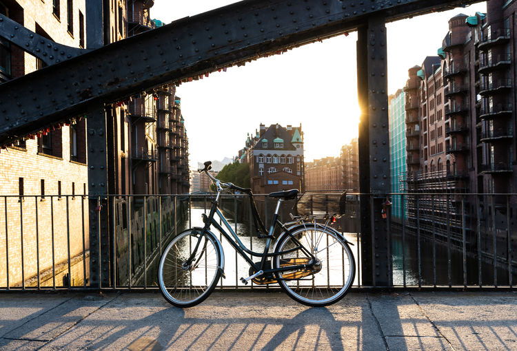 Bicycle on bridge against buildings in city