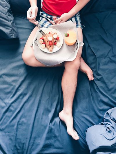 Low section of man having breakfast in bed