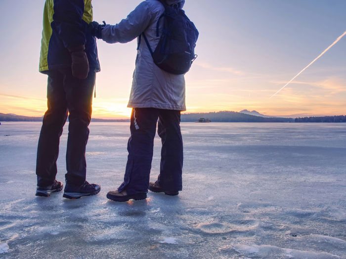Couple, man and woman walking on the ice on frozen lake. happy couple on a frozen lake on winter day