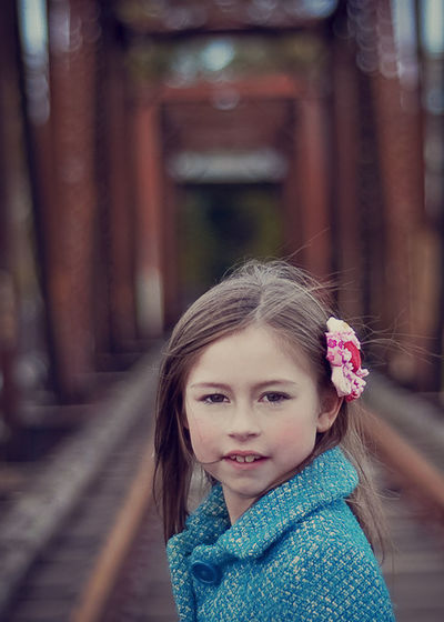 Portrait of girl standing on railroad track