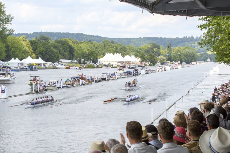 People on riverbank against sky