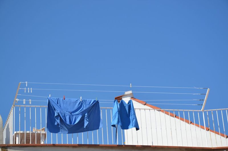 Low angle view of blue fabrics drying on clothesline